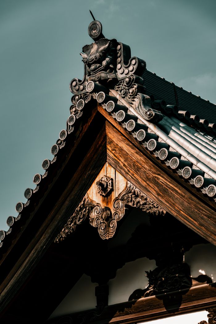 Mastering the First Impression: Your intriguing post title goes here Close-up of ornate traditional temple roof in Kyoto, showcasing intricate woodwork and design.